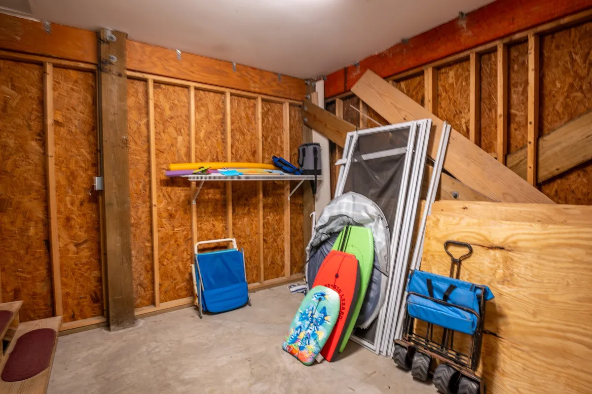 The image features neatly stored surfboards on a storage cart and a well-organized shelving unit, emphasizing the presence and ease of storing recreational and beach equipment. The practical organization hints at readiness for spontaneous outings.