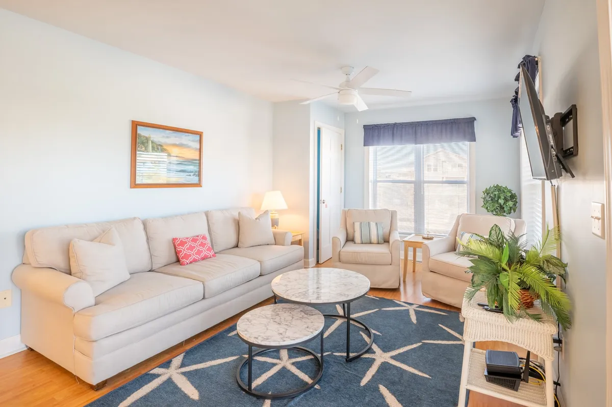 A cozy living area featuring a comfortable sofa, coffee table, vibrant plants, and a window that hints at views beyond. This inviting space is ideal for relaxing together after a day of exploring, with plenty of room for socializing, watching TV, or enjoying coffee as a group.